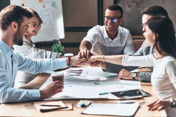 Osoba pracująca przy biurku z notatnikiem i laptopem.